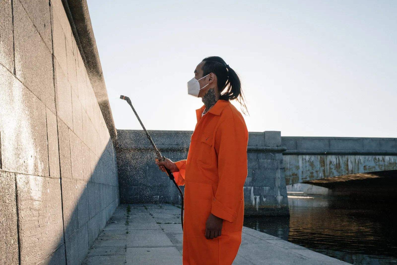 A pest control technician treating the exterior wall of a home